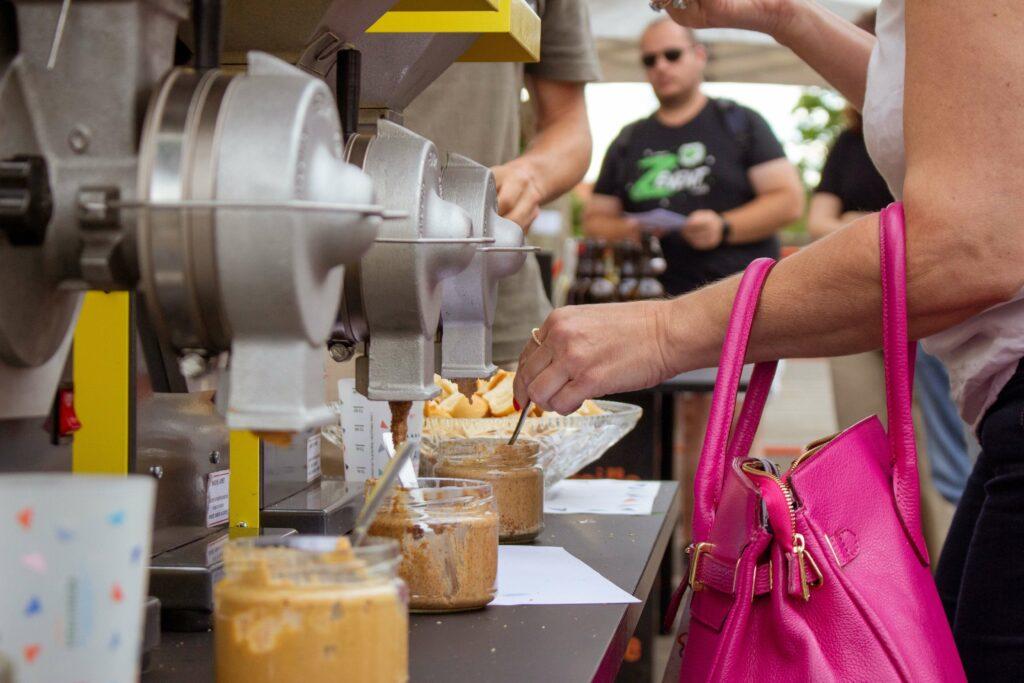 Des moulins Grindelice en service, une dame se sert dans le pot de pâte à tartiner